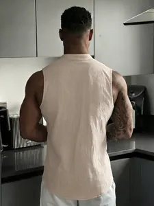 Back view detail of a men's beige sleeveless linen shirt in a modern kitchen setting