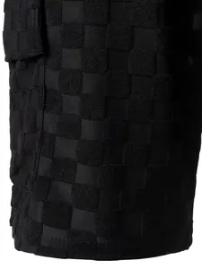Macro view showing the detailed black checkerboard jacquard texture of men's shorts