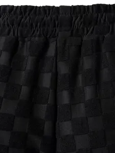 Detail shot of black men's casual shorts with jacquard checkerboard pattern and elastic waist