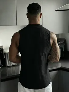 Rear view of a men's black sleeveless linen Henley shirt worn in a modern kitchen setting