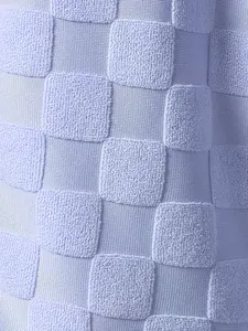 Vue macro détaillée d'un tissu jacquard à damier lavande montrant la texture douce