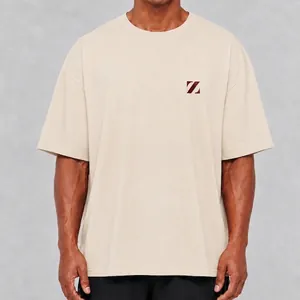 Detailopname van een oversized gewassen katoenen t-shirt in beige met minimalistisch logo.