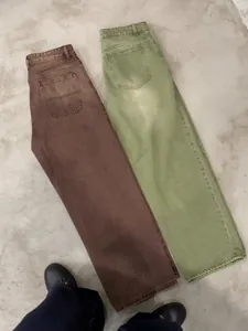 Close-up detail of matcha green and coffee brown loose wide-leg washed gradient denim jeans