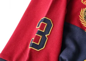 Close-up detail of a cotton sports polo shirt featuring an embroidered number 3