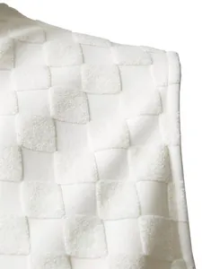 Vue détaillée de la texture du tissu jacquard à damier blanc pour débardeur d'été homme.
