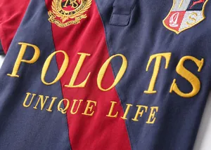Close-up of premium embroidered POLO TS logo on color block cotton mesh polo shirt.
