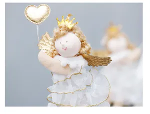 Detailed shot of a plush Christmas angel ornament with golden wings and heart balloon
