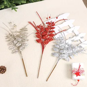 Tiges de feuilles et baies de Noël artificielles pailletées en or, rouge et argent.