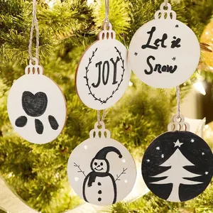 Set of white wooden Christmas ornaments with festive designs hanging on tree
