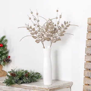 Feuilles et baies artificielles dorées à paillettes pour une décoration de Noël chic
