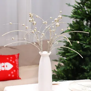 Branches de Noël à baies dorées pailletées dans un vase blanc pour décor de fête