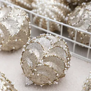 Elegantes bolas de Navidad oro champán con perlas blancas y decoraciones brillantes