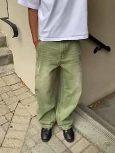 Detail view of matcha green wide-leg jeans with washed gradient effect on a model