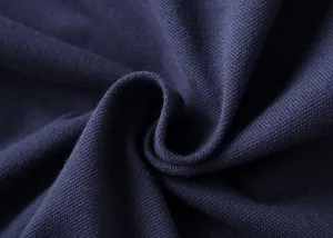 Macro view of navy blue pique cotton fabric showing detailed breathable knit texture.
