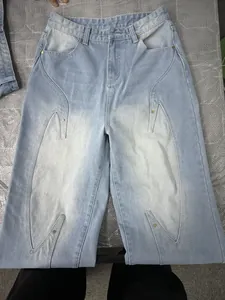 Artistic light blue washed straight leg denim jeans with unique stitching and metal studs