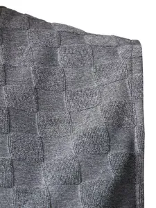 Détail macro d'un tissu jacquard à damier pour hommes montrant la texture du tricot.