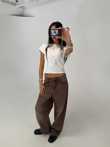 Professional studio shot of a model wearing trendy wide-leg brown washed denim pants