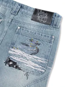Straight washed denim jeans featuring intricate fallen angel embroidery