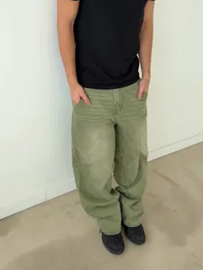 Full view of matcha green wide-leg denim pants with washed gradient effect on model