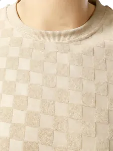 Gros plan sur la texture jacquard à damier beige et le col rond côtelé du débardeur