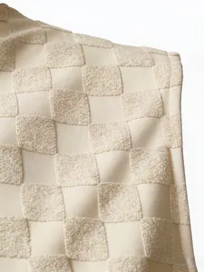 Gros plan détaillé de la texture du tissu jacquard à damier beige pour débardeur