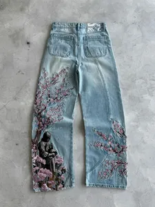 Jeans in denim azzurro con ricami di fiori di ciliegio e cavaliere medievale rifiniti