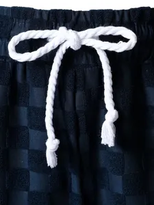 Close-up detail of navy checkered jacquard fabric and white cotton drawstring waist.