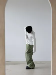 Oversized matcha green wide-leg denim jeans shown on model in a minimalist studio setting