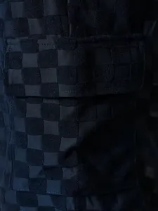 Close-up of navy checkered jacquard fabric texture and pocket on men's summer shorts.