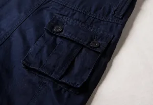 Close-up detail of back flap pocket with resin buttons on navy cargo pants detail