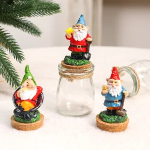 Trois figurines de nains de Noël en résine sur bouchons avec un petit bocal en verre