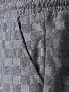 Close-up detail of gray checkerboard jacquard terry cloth shorts with side pocket