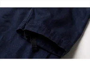 Close-up detail of navy blue cotton cargo pants cuff showing reinforced stitching quality