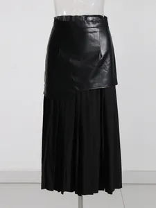 Primer plano de falda midi plisada de cuero sintético negro sobre maniquí