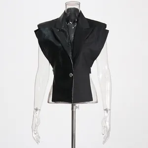 Detailopname van zwart patchwork gilet met krokodillenstructuur op transparante pop