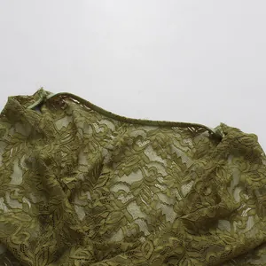 Primer plano detallado de la tela de encaje verde oliva con complejos patrones florales