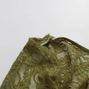 Detalle de top de encaje verde con estampado floral y cuello con abertura de lágrima.