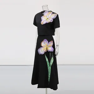 Elegante conjunto francés de dos piezas con apliques florales 3D en top y falda negros.