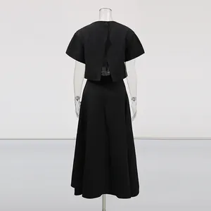 Vista trasera de un elegante conjunto negro de dos piezas estilo francés con top y falda en A