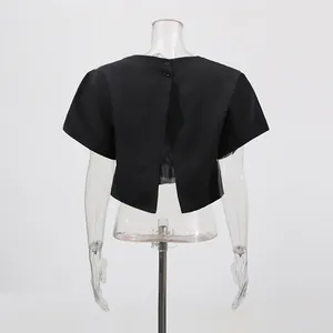 Vista trasera de un elegante top corto negro de manga corta con detalle de espalda abierta