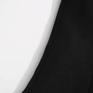 Macro close-up detail of black fabric texture and fine stitching on a slim blazer