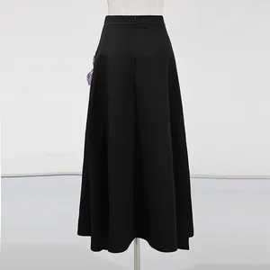Vista trasera de falda larga negra de corte A de talle alto con detalle floral