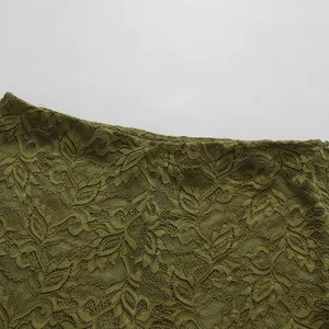 Primer plano del tejido de encaje floral verde oliva de los pantalones