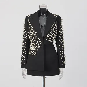 Vue détaillée d'un ensemble deux pièces noir avec veste à perles et mini-jupe assortie
