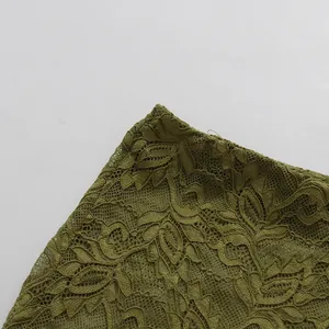 Primer plano de tela de encaje calado verde oliva con intrincados patrones florales