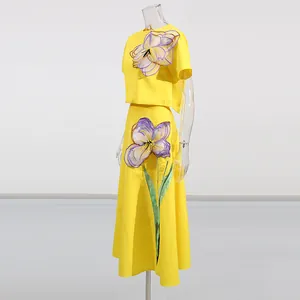 Vista detallada del conjunto amarillo de dos piezas con apliques florales de iris en 3D