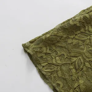 Primer plano detallado que muestra la intrincada textura del tejido de encaje verde oliva.