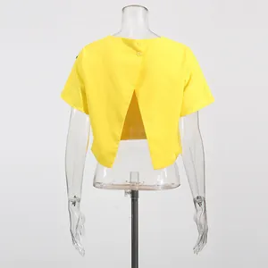 Detalle de blusa amarilla de manga corta con elegante diseño cruzado y botones en la espalda