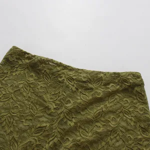 Primer plano del detalle del pantalón acampanado de encaje verde con calados