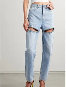 Detailed view of high-waisted jeans featuring rhinestone-embellished cut-outs on thighs